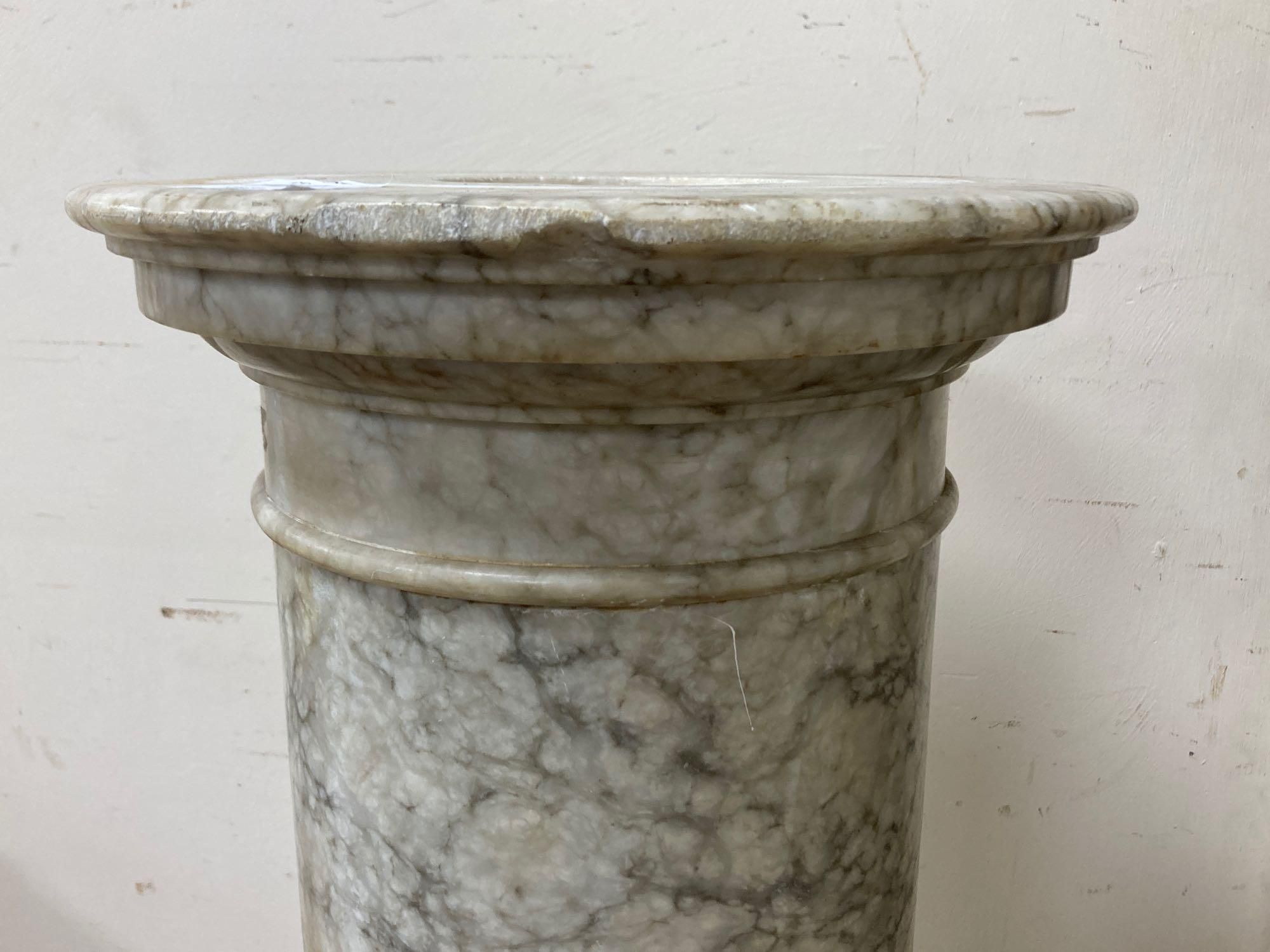 A variegated cream marble pedestal, height 110cm